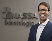 Dr. Camilo Massa sorrindo na clínica